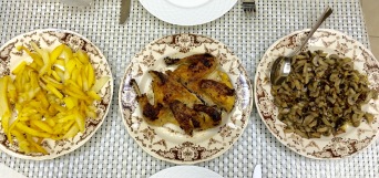 Tabaka chicken (baby chicken pan fried flattened under a weight) with sides of pan fried potatoes and mushrooms